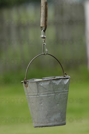 Dented metal bucket on wellstick