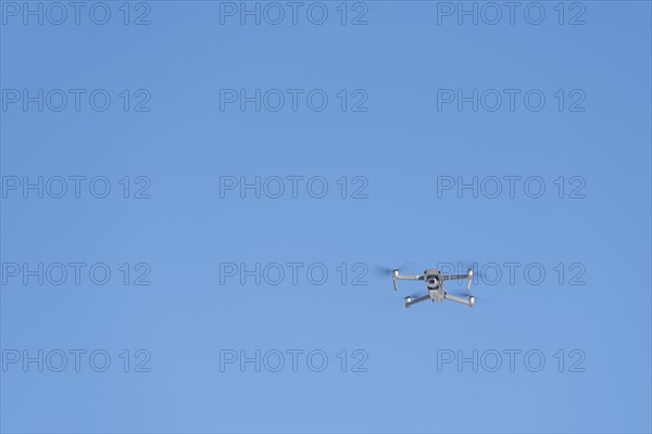 Drone flies in front of blue sky