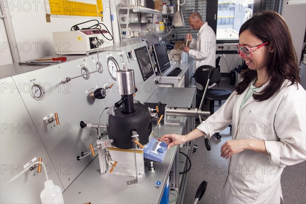 Scientist at the high-pressure machine for simulating conditions deep in the earth for research on the origin of life