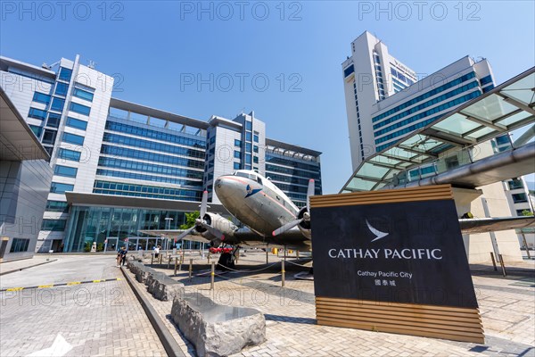 A Douglas DC-3 aircraft with registration VR-HDA in front of Cathay Pacific City at Hong Kong Airport