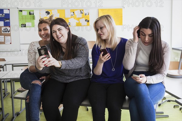 Vocational school students with their smartphones during break at the Elly-Heuss-Knapp-Schule