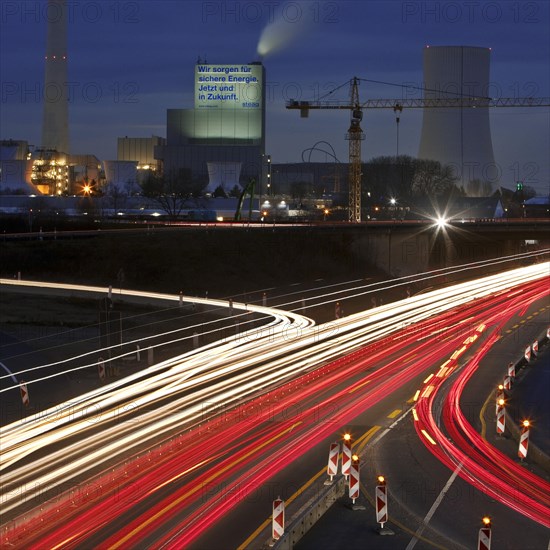 Light traces in the evening on the motorway A 43 with the Steag power plant Herne in the background