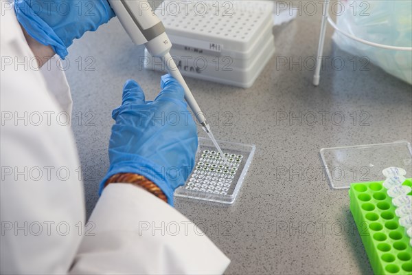 Student of the faculty of biology at the University of Duisburg-Essen during research work pipetting