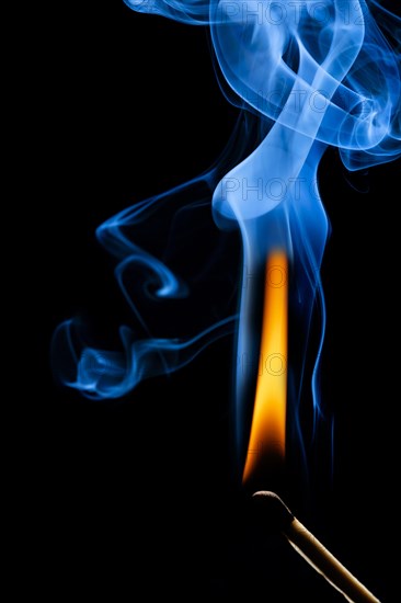 Burning match with blue smoke