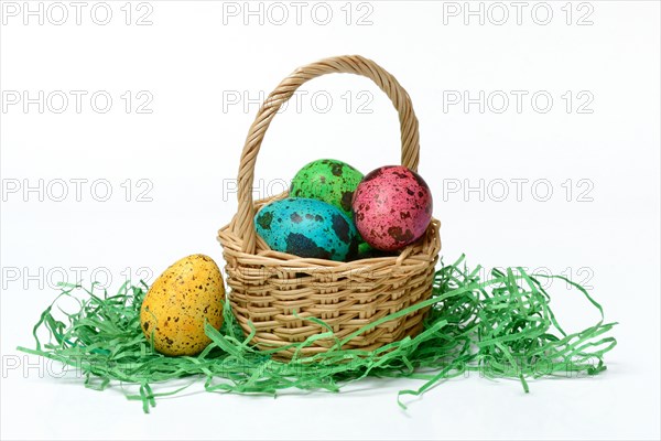 Coloured quail eggs in baskets