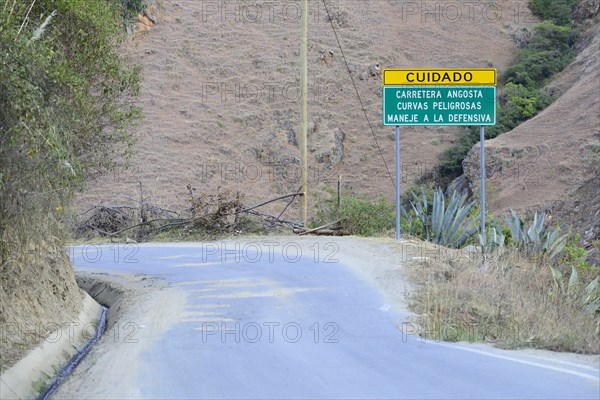 Warning sign at curvy road