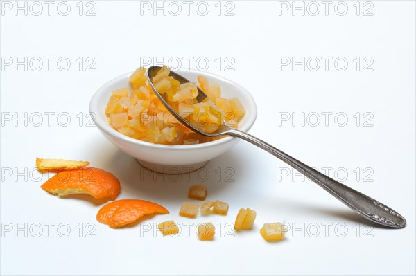 Candied orange peel cubes in small bowls and spoon