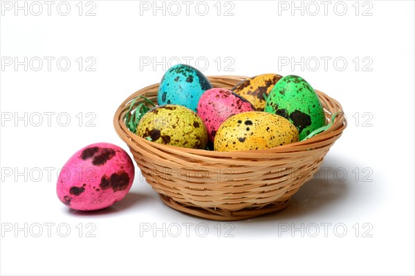 Coloured quail eggs in baskets