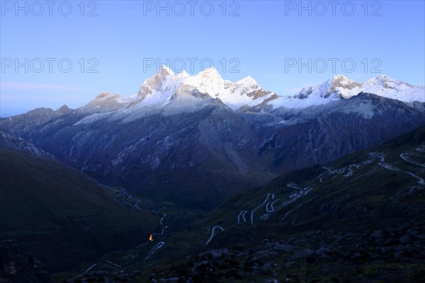 Winding mountain road and massif of Nevado Huandoy at dawn