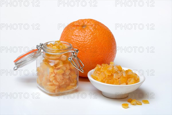 Candied orange peel cubes in glass and peel