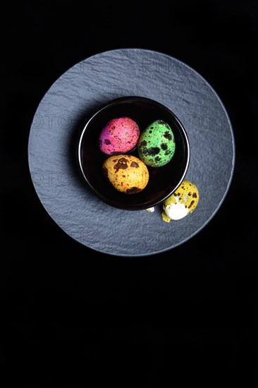 Coloured quail eggs in small bowls