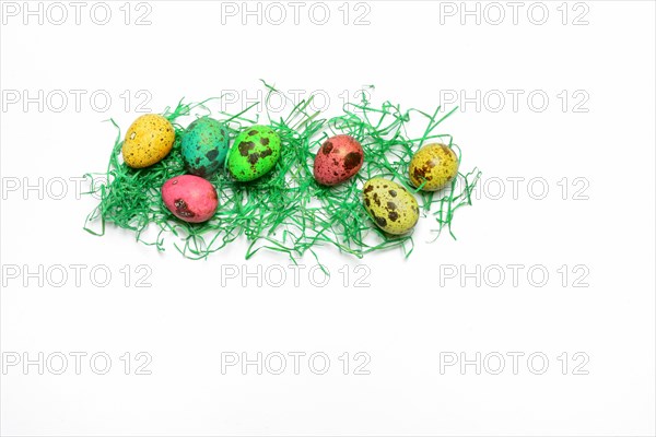 Colored quail eggs with decorative grass