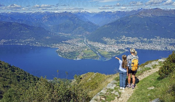 Mother and daughter looking at the Maggia delta with Ascona and Locarno at the end of the Valle Maggia