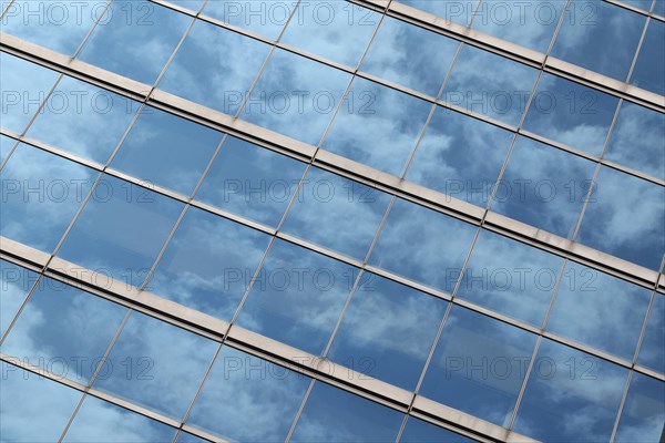 Glas facade with reflection of blue sky and clouds on a business building in Ginza district