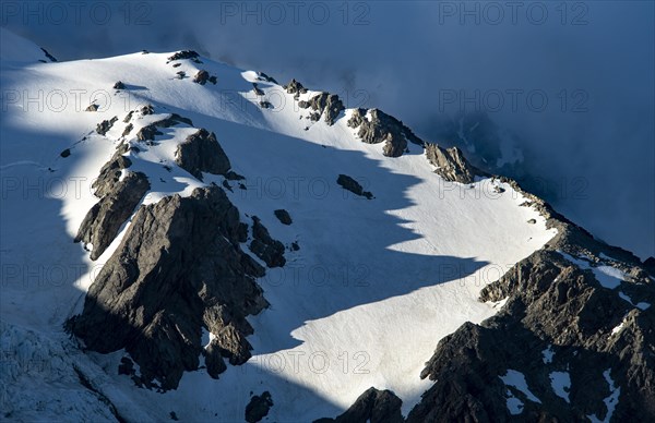 Snow covered rocky mountainside in evening light
