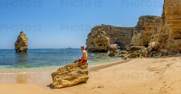 Young man sitting on a rock