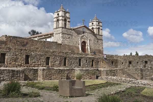 Stone throne in front of the Inca Sun Temple with attached cathedral from the colonial period