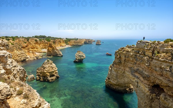 Young man standing on a rock on the cliff