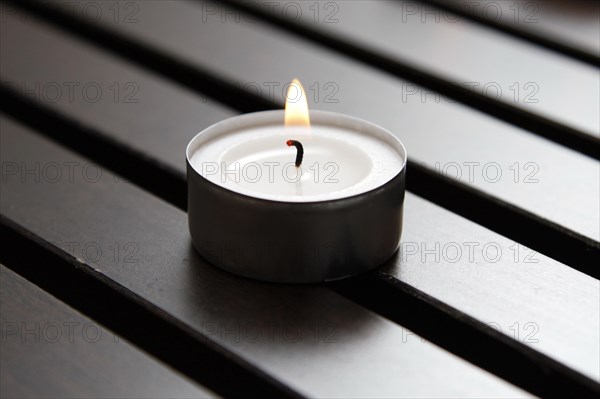 Tea light on wooden background