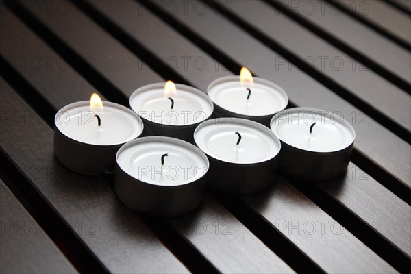 Tea lights on wooden background