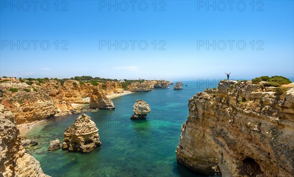 Young man standing on a rock on the cliff