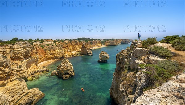 Young man standing on rocks on cliff