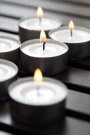 Tea lights on wooden background