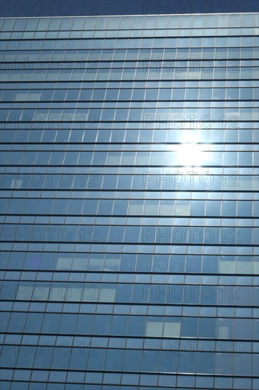 Glas facade of a business building with reflecting sun in Ginza district