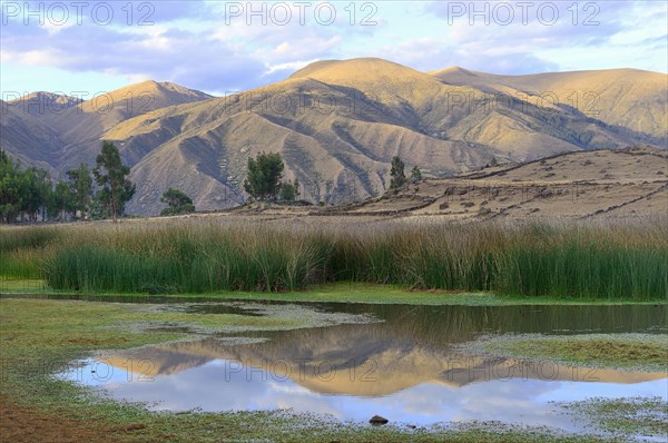 Reflection of bare hills in the Laguna Pumaqucha at the Inca ruins of Inti Watana