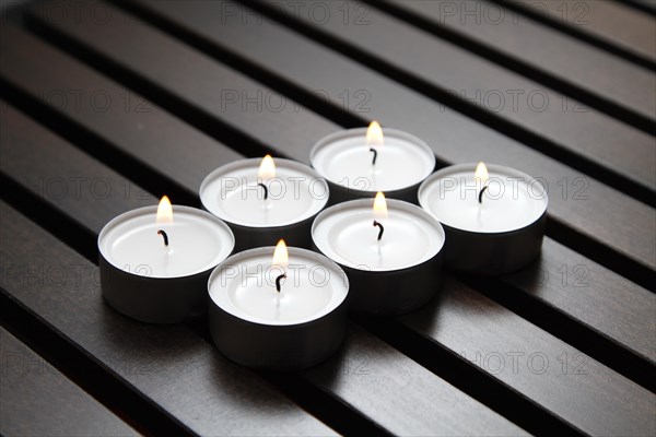 Tea lights on wooden background