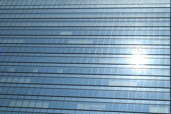 Glas facade of a business building with reflecting sun in Ginza district