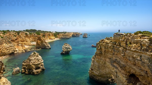 Young man standing on a rock on the cliff