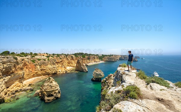 Young man standing on rocks on cliff
