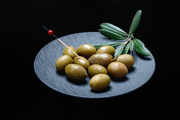 Greek olives from Chalkidiki on plate with toothpick