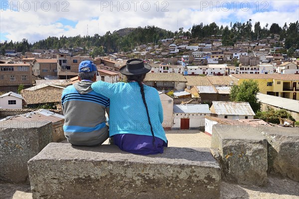 Old indigenous couple looking down from the Inca ruins