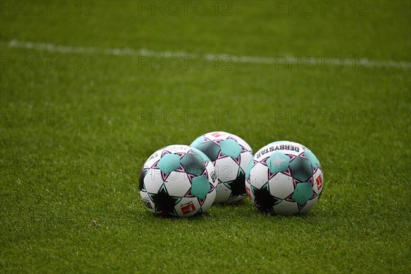 3 adidas Derbystar footballs lie on grass