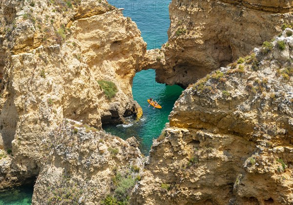 Kayak in the turquoise sea driving through rock arches