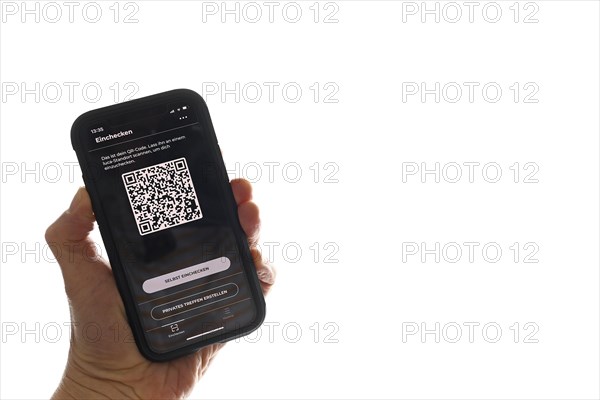 Hand holds smartphone with Luca app with QR code in front of window