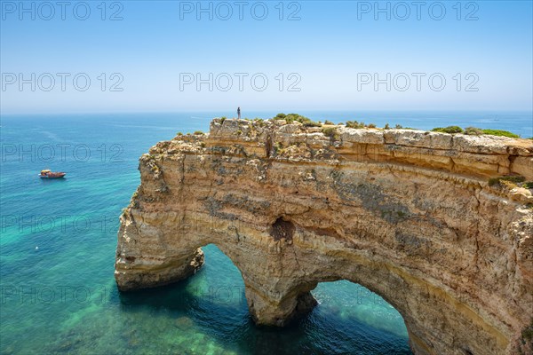 Young woman standing on a rock on the cliff