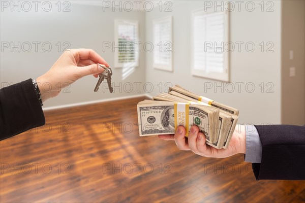 Real estate agent hands over new house keys for cash inside empty room