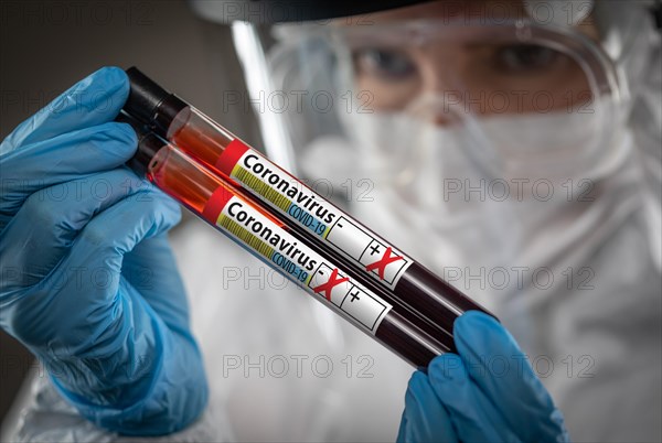 Female Lab Worker Holds Test Tubes of Blood Labeled Coronavirus COVID-19 Disease