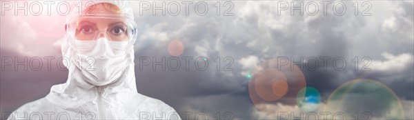 Doctor or Nurse Wearing Personal Protective Equipment Over Stormy Clouds Banner