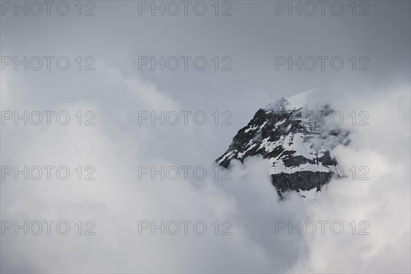 Snow covered mountain peaks in clouds