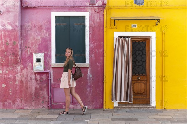 Young woman in front of colorful house