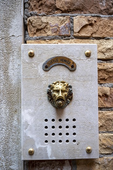 Bell in the shape of a lion on a house wall