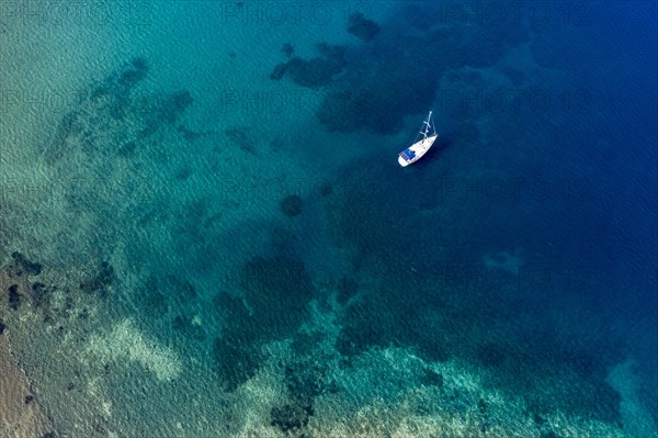 Aerial of a sailing boat in the clear waters of Limnionas beach