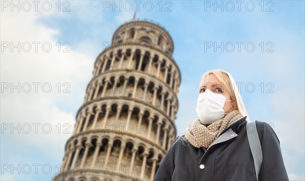 Young Woman Wearing Face Mask Walks Near The Leaning Tower of Pisa In Italy