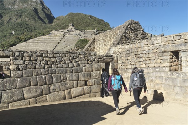 Hiker with backpack in the ruined city of the Incas