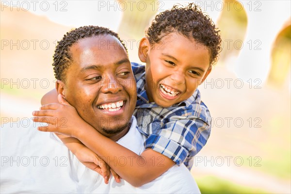 Happy african american father and mixed race son playing at the park