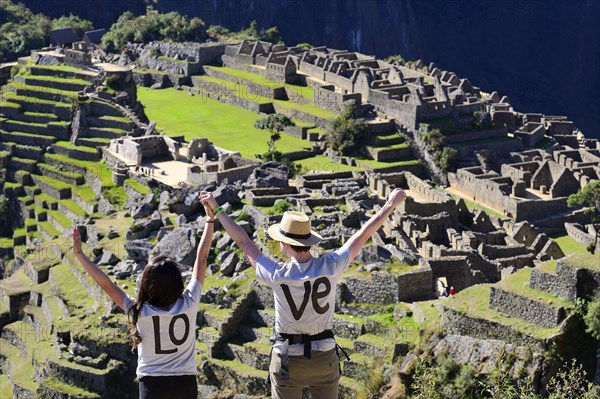 Two tourists wearing T-shirts with Love on them in the ruined city of the Incas